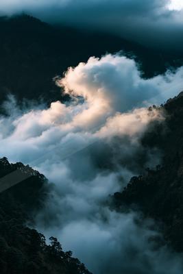 A dramatic long exposure sky scene of clouds, mountains, valley.