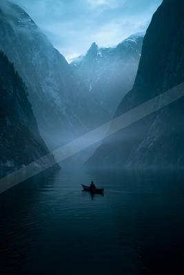A black-toned moody photograph of killer whale, canoe, paddle.
