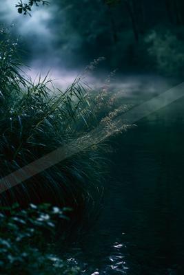A moody landscape of field, river, lake.