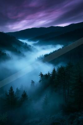 A blue hour panorama landscape of a valley, fog.