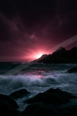 A black-toned moody photograph of promontory, seashore, cliff.