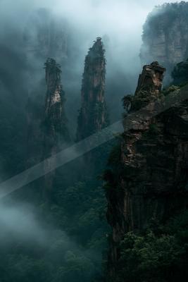 A moody landscape of mountains, valley, forest.