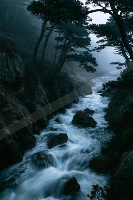A dramatic long exposure water scene of river, waterfall, fog.