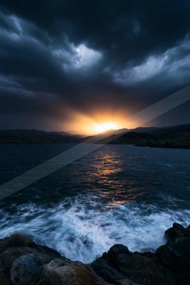 A dramatic long exposure sky scene of storm, sunset, ocean.
