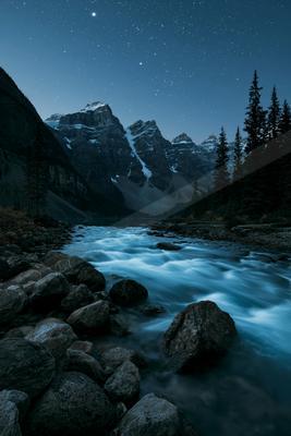 A night long exposure water scene of river, mountains, valley.