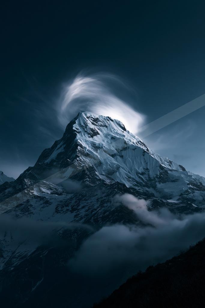 A night landscape of mountains, moon, storm.