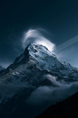 A night landscape of mountains, moon, storm.