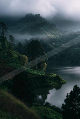 A serene water scene of lake, valley, mountains.